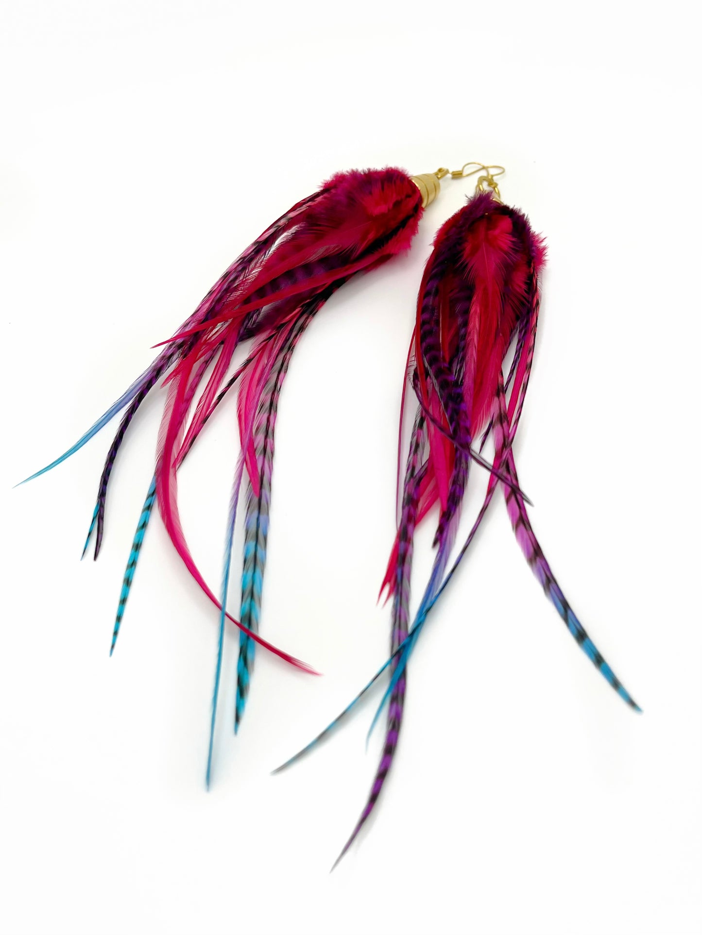 Long pink, purple and blue feather earrings. All feathers hang under a gold colored pendant.