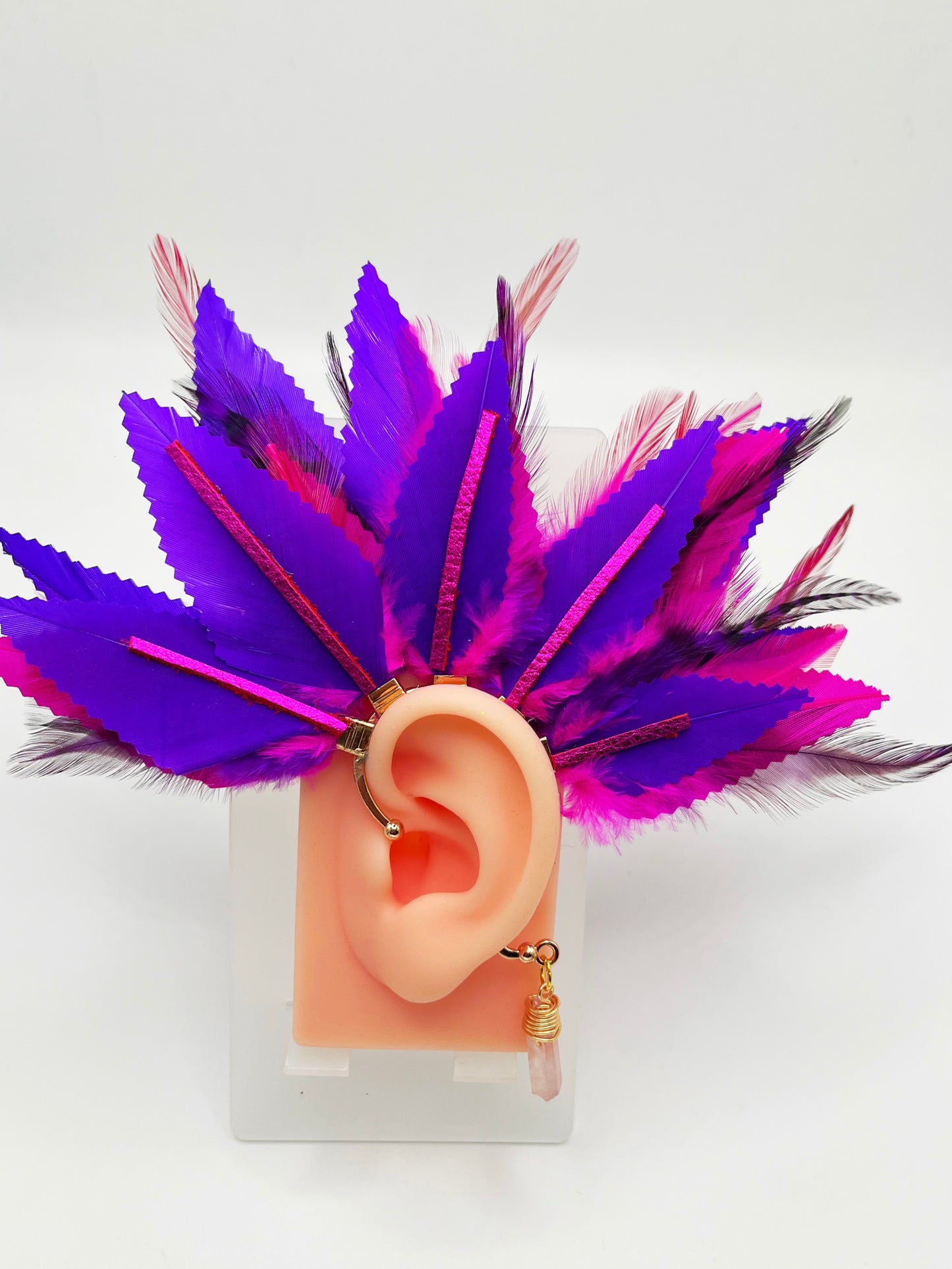 Structured purple and pink feather ear cuff with pink leather accents and a wire wrapped quartz, modeled on an ear.