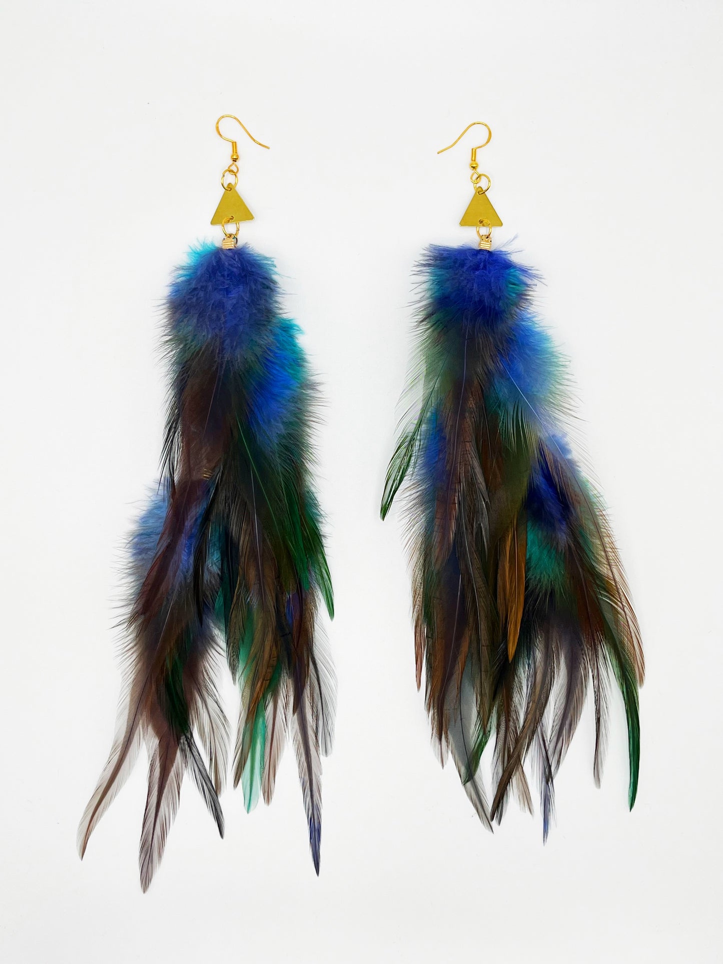 Long bohemian feather earrings in blue, gray and turquoise tones, with gold triangle pendants.