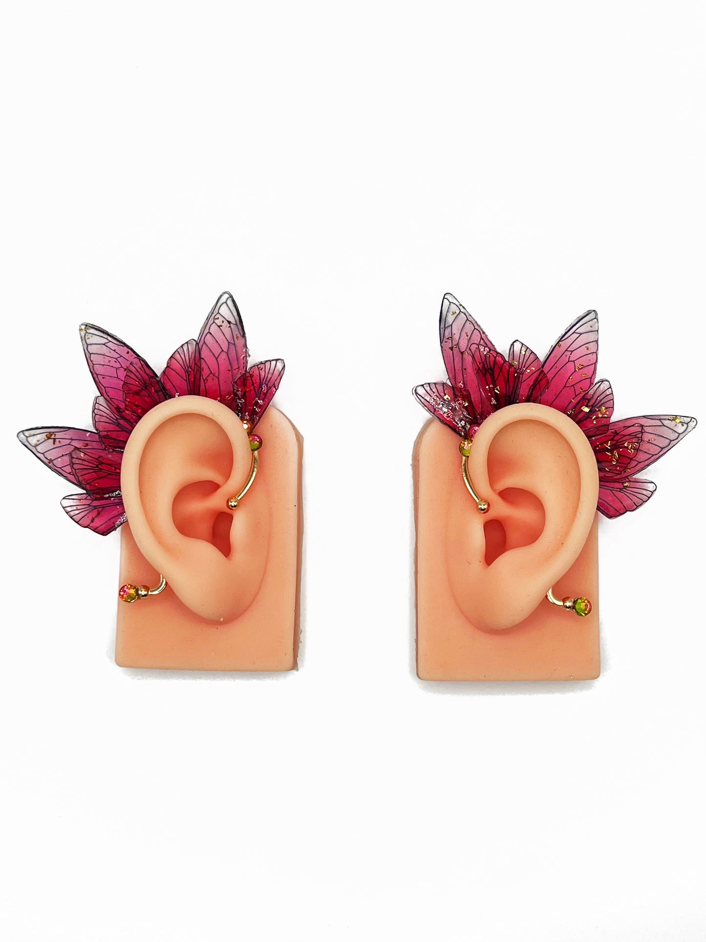 Red fairy wing ear cuffs modeled on a pair of ears.