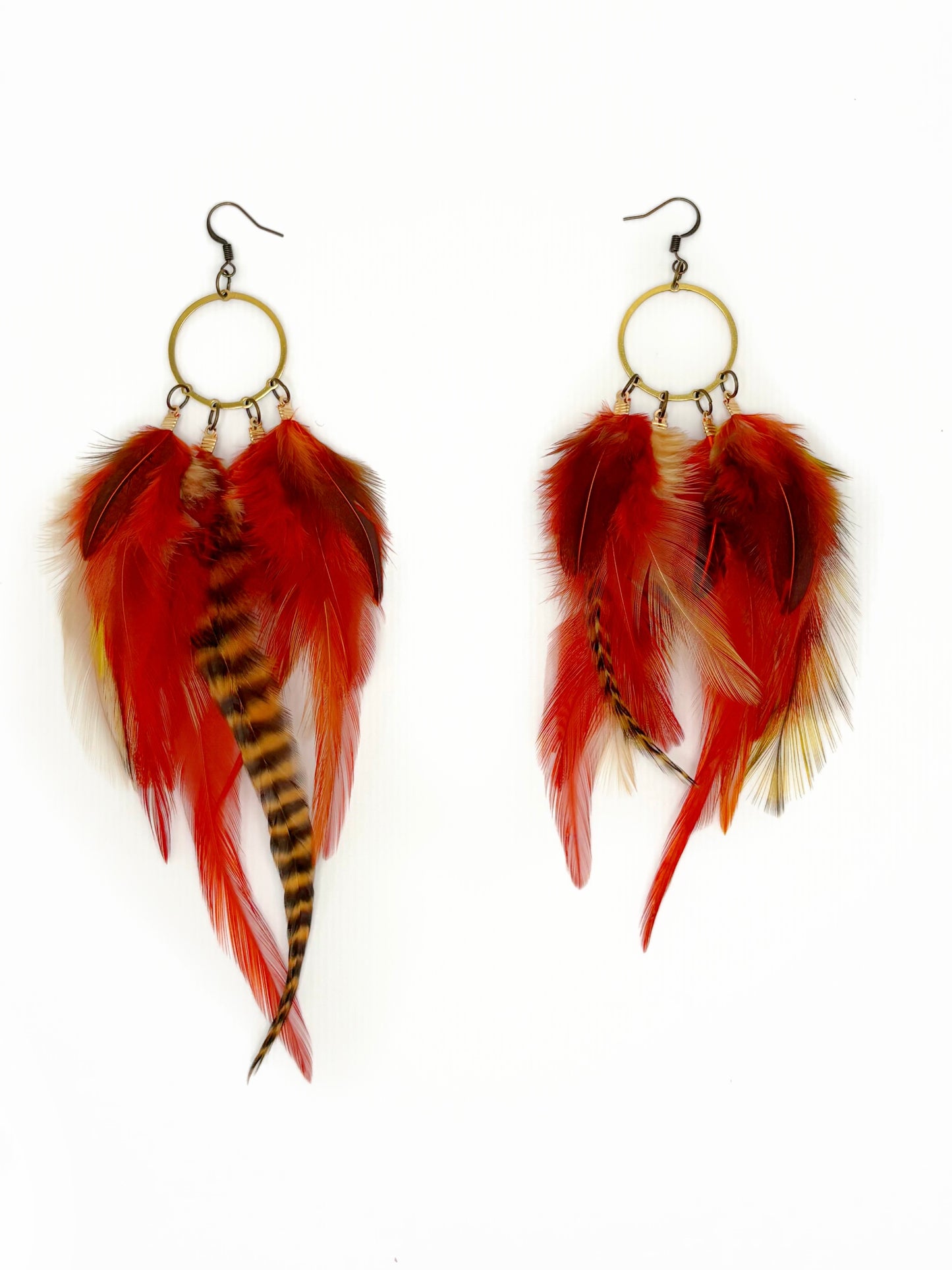 Feather earrings with red, orange, and black feathers on a white background