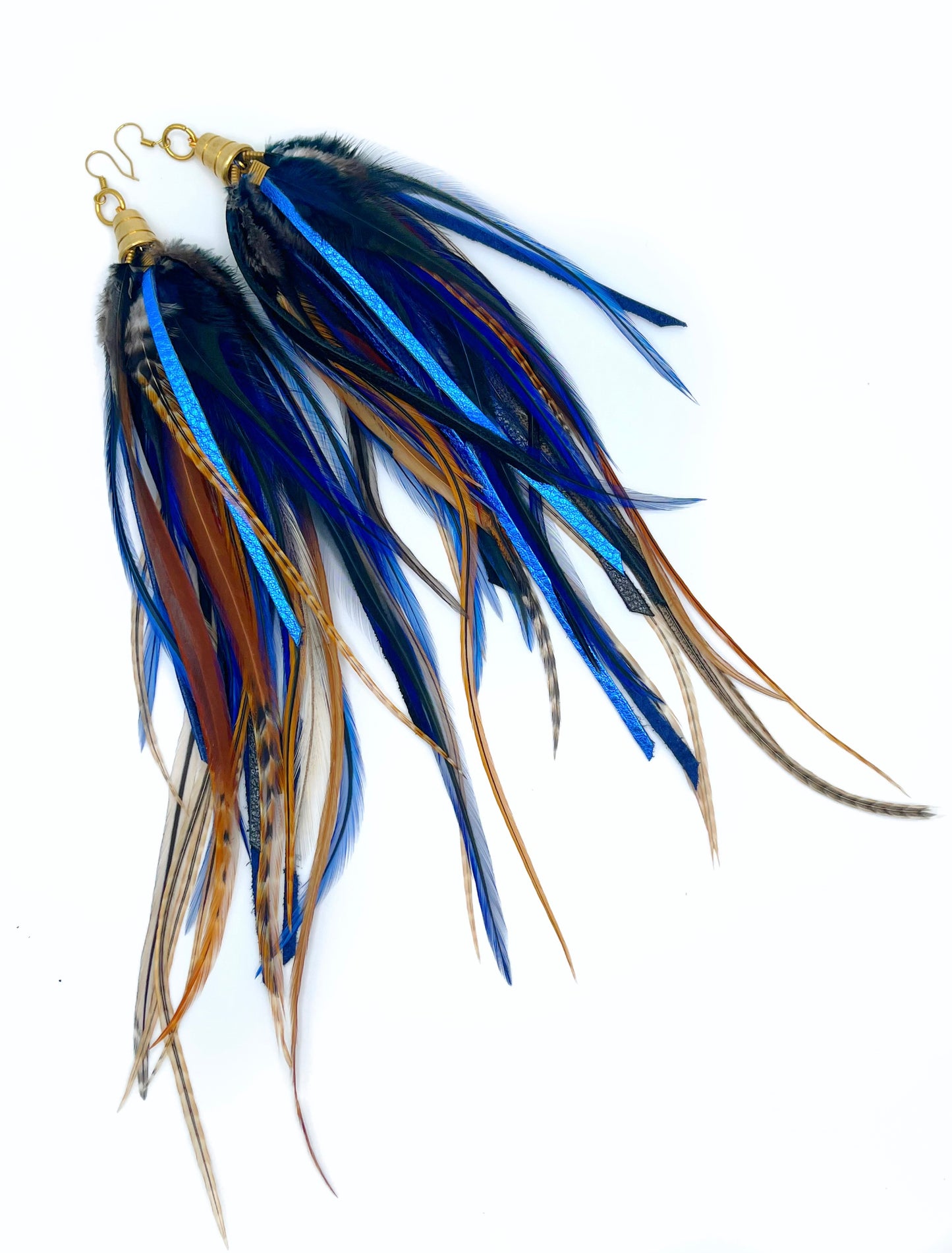 Long feather and leather earrings in dark blue and brown tones. All feathers hang from underneath a gold cap pendant.