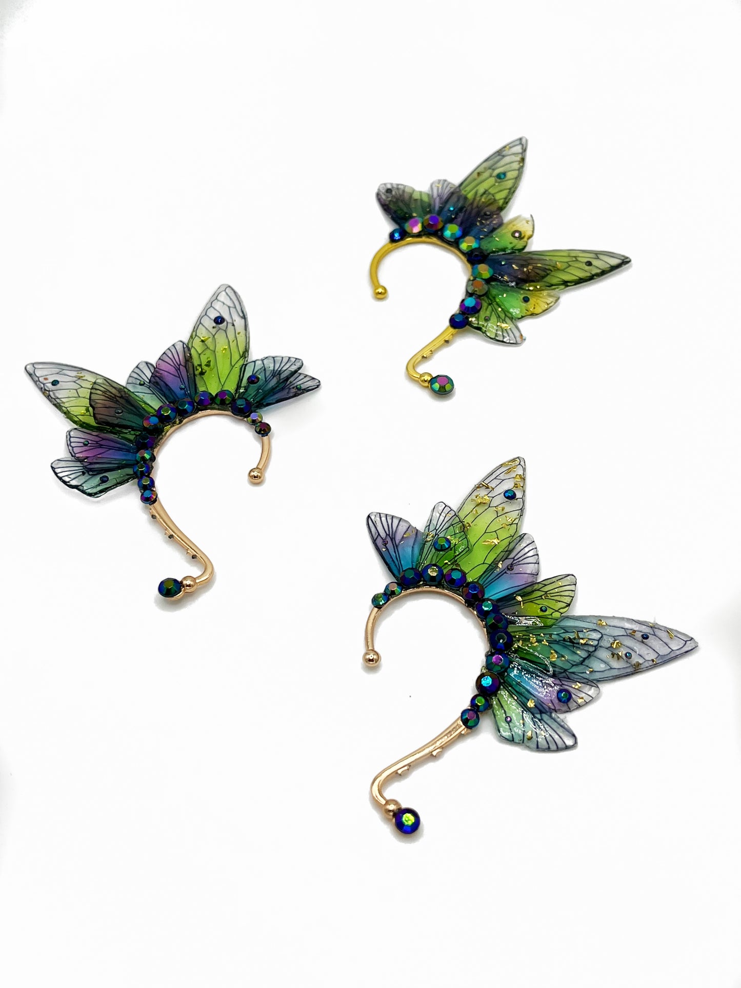 Green and purple fairy wing ear cuffs with blue rhinestone accents.