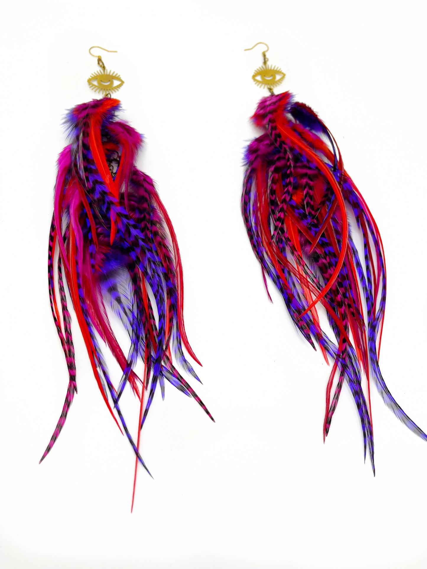 Long fluffy feather earrings in red and purple tones. All feathers hang elegantly from an evil eye pendant.