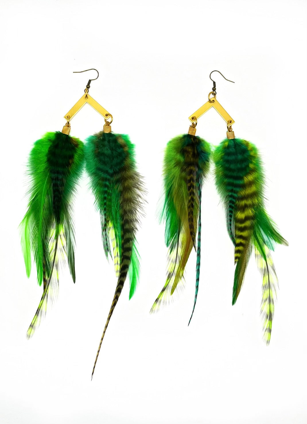A pair of handmade earrings featuring an array of vibrant green and yellow grizzly feathers, attached to golden arrow pendants. The feathers vary in pattern and hue, some with striking black stripes, creating a lush, tropical aesthetic.