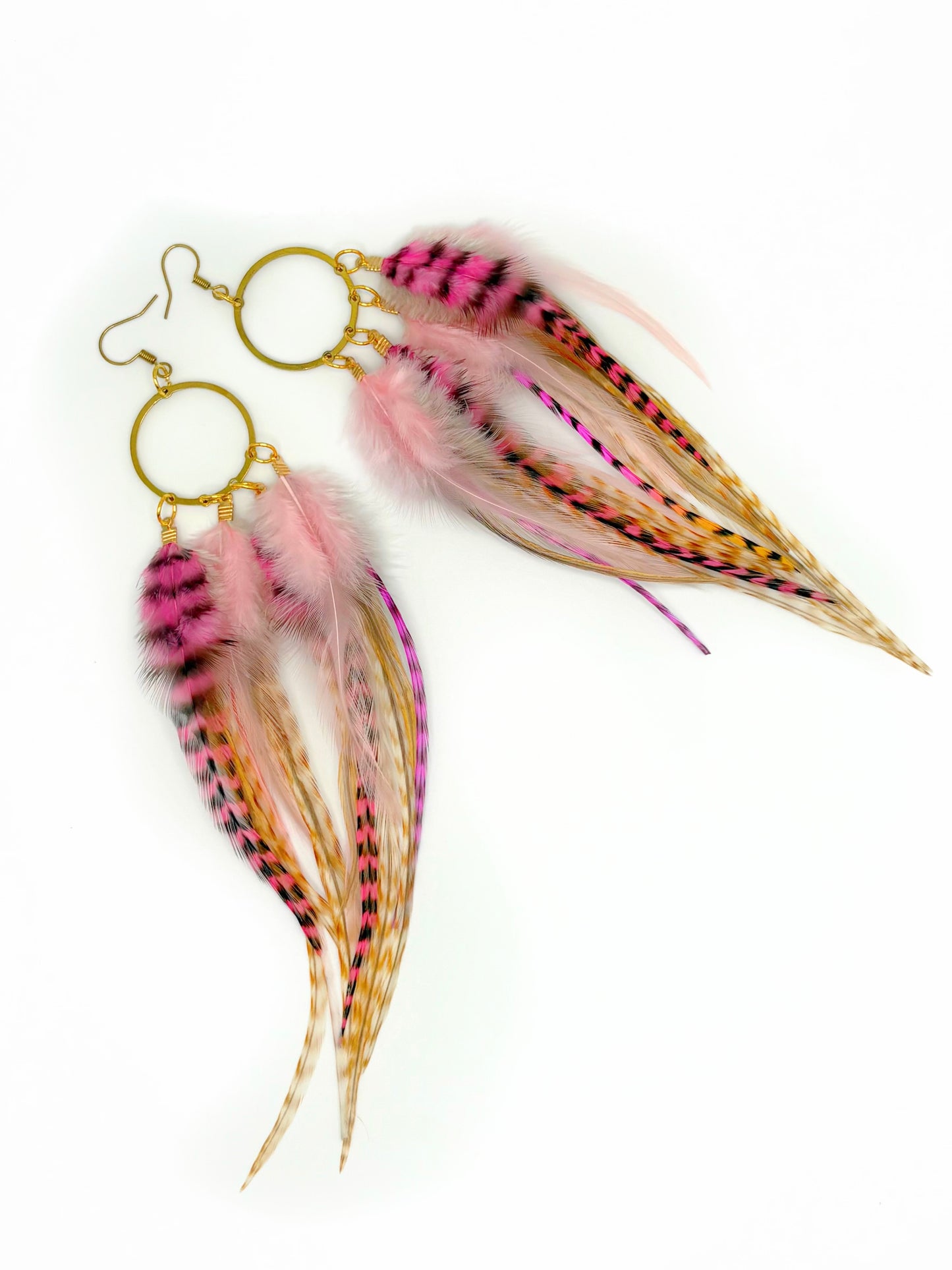 Feather earrings with pink and gold colors on a white background