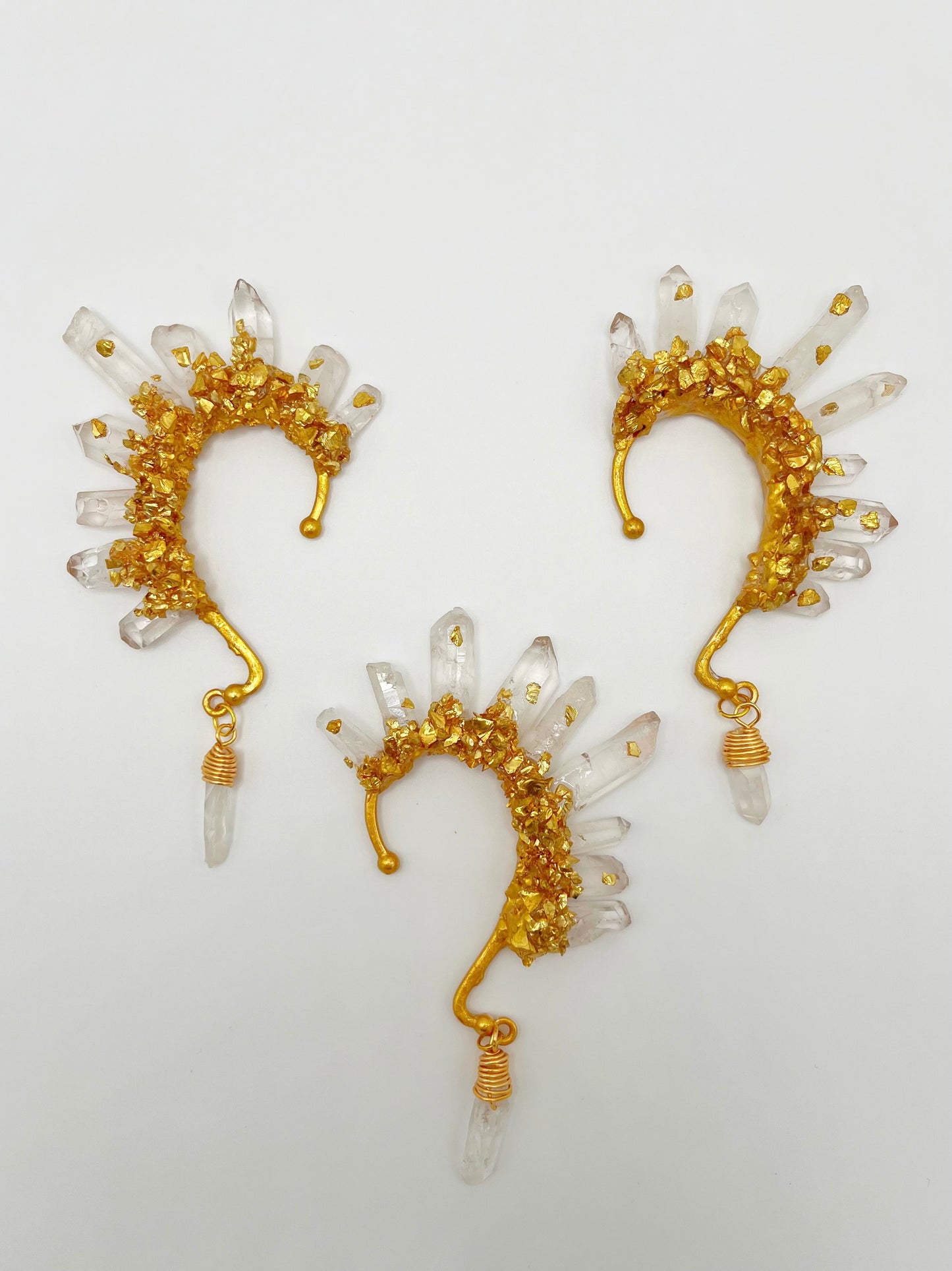 Clear quartz crystal ear cuffs with crushed gold accents. Wire wrapped quartz stones hang from the bottom of the cuffs.