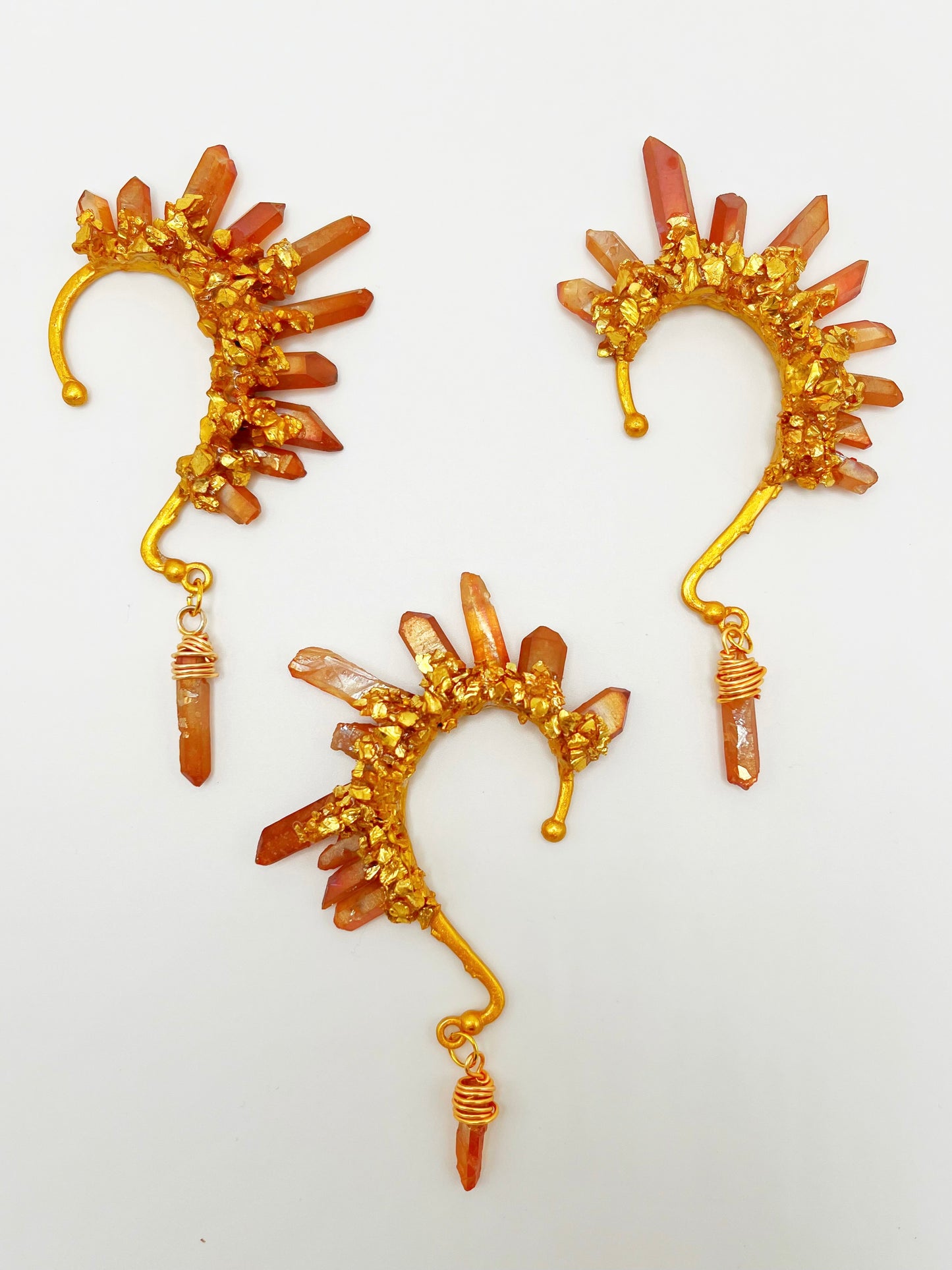 Three orange citrine crystal ear cuffs with crushed gold accents. A wire wrapped stone hangs from the bottom of each cuff.