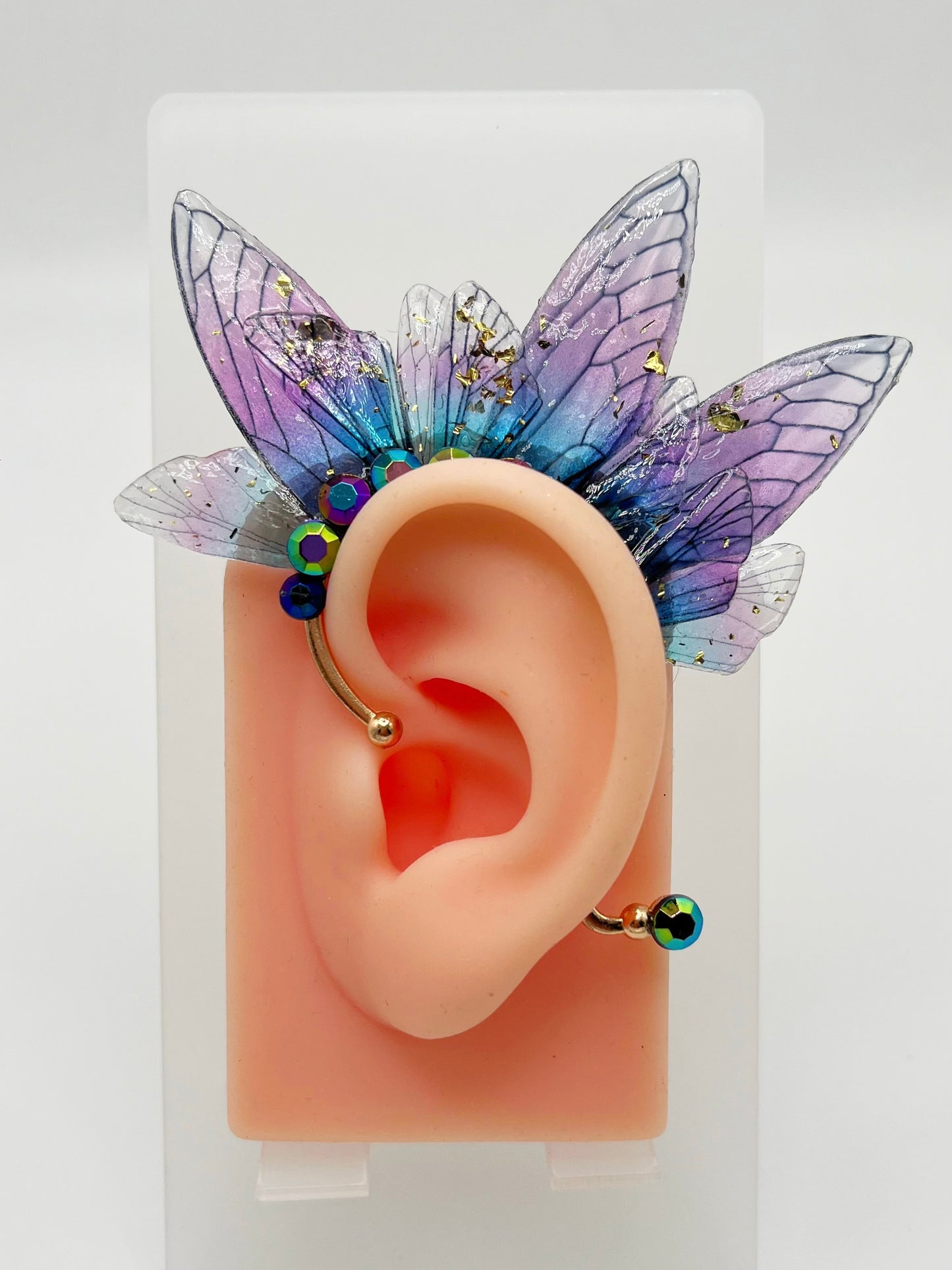Purple blue fairy wing ear cuff, modeled on an ear.
