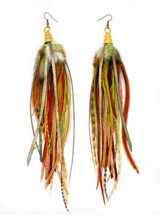 Long feather earrings in green and brown tones, with hand cut metallic leather. All feathers and leather hang from a gold colored bead cap.