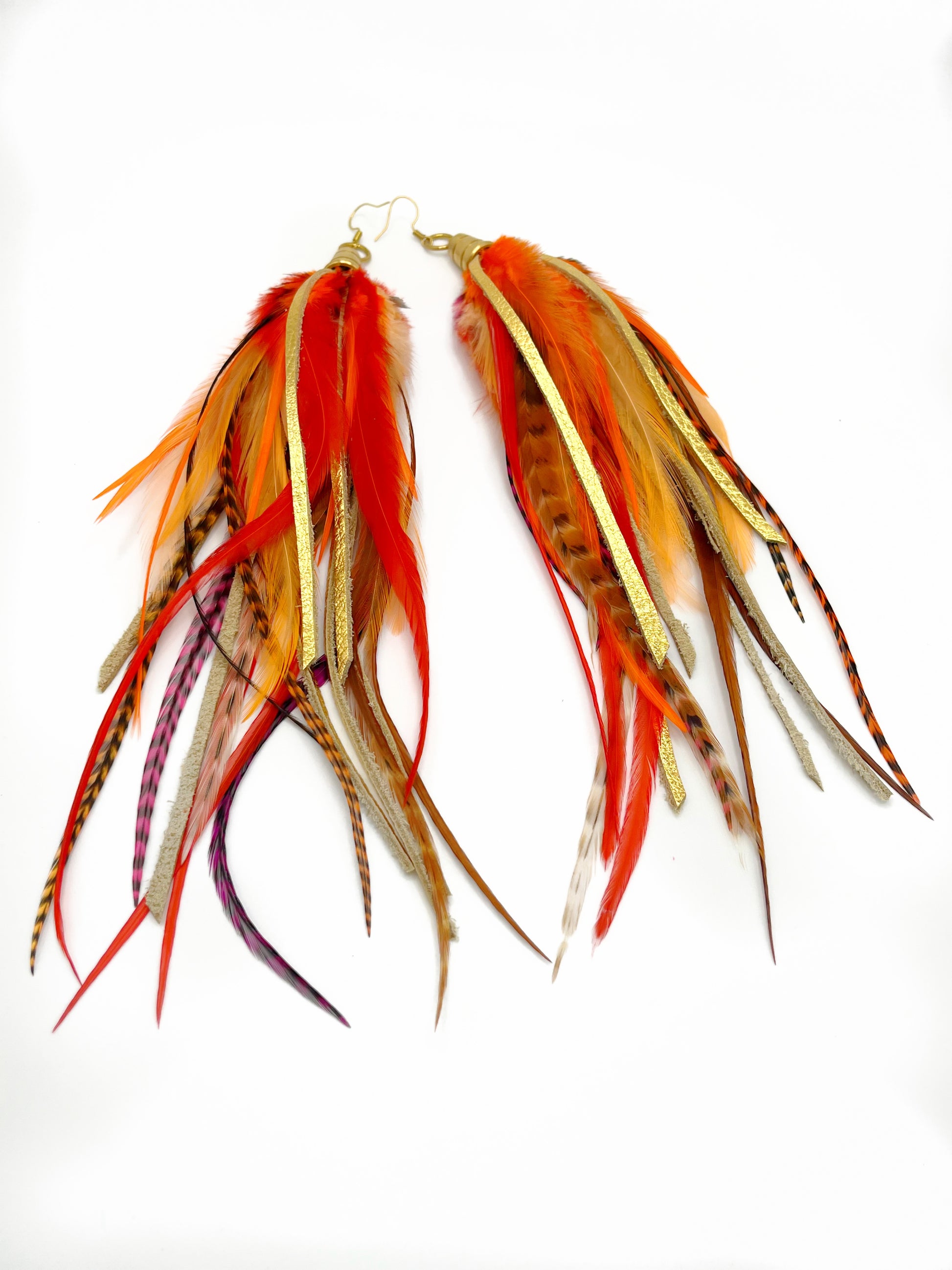 Long bohemian feather earrings with bright orange feathers, metallic gold leather and gold colored pendants.