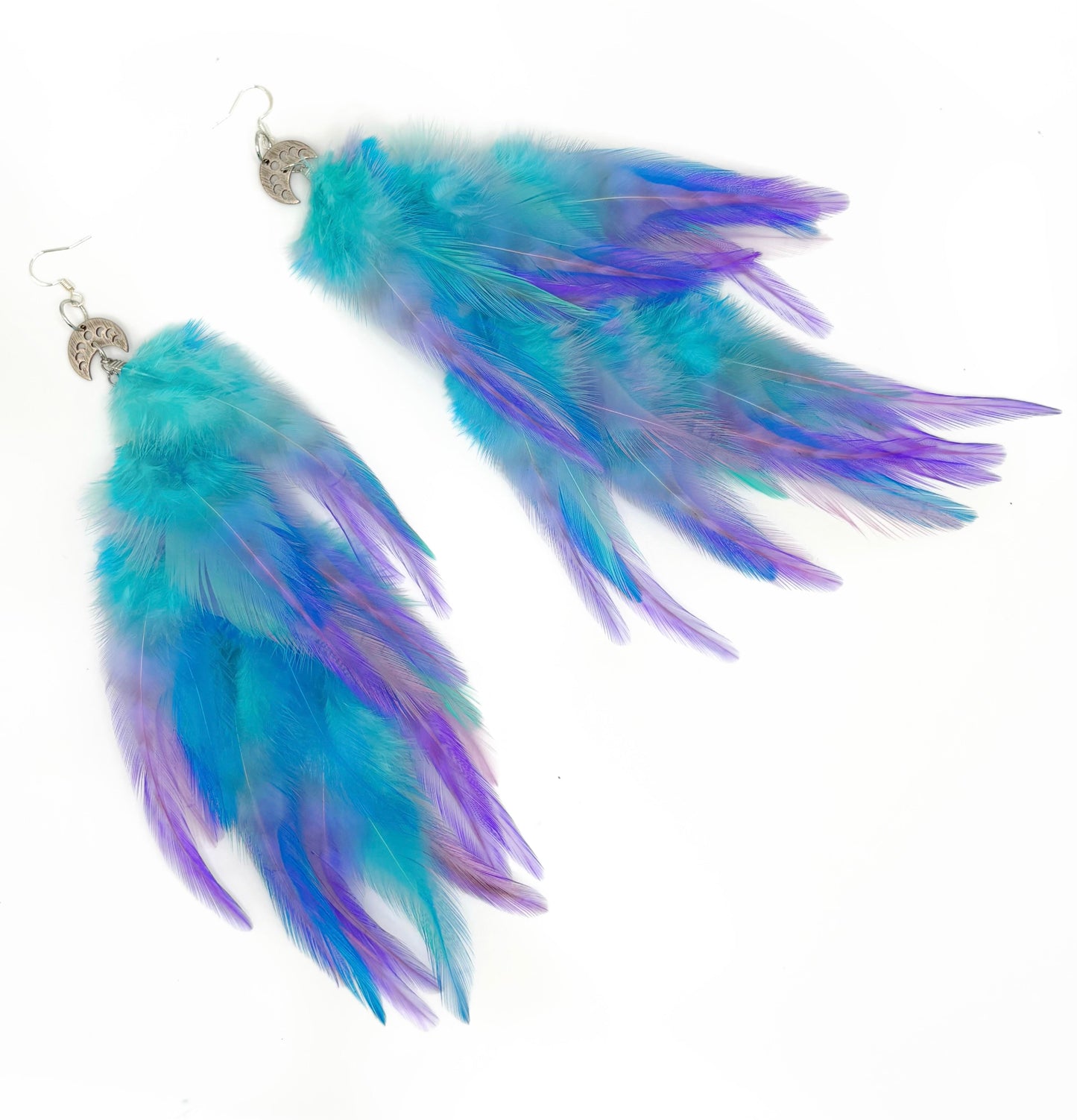 Turquoise and purple feather earrings on a white background