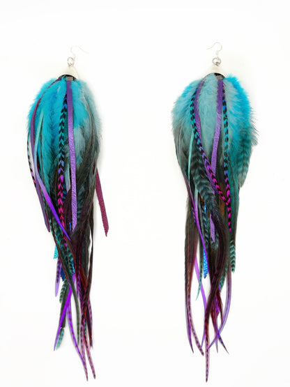 Feather earrings with blue, purple, and black strands on a white background