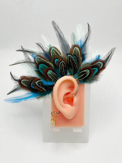 Turquoise blue, mint green and gray pheasant and rooster feather ear cuff, modeled on an ear. A wire wrapped quartz stone hangs from the cuff behind the ear. 