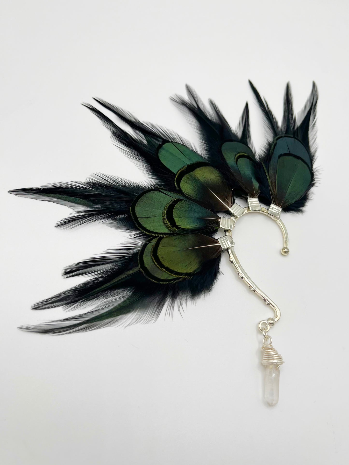 Black rooster and emerald green lady Amherst feather ear cuff. A wire wrapped quartz stone hangs from the bottom of the cuff.