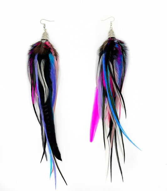 Long fluffy feather earrings in black, white, blue, purple and hot pink tones. All feathers hang from underneath a silver cap pendant. 