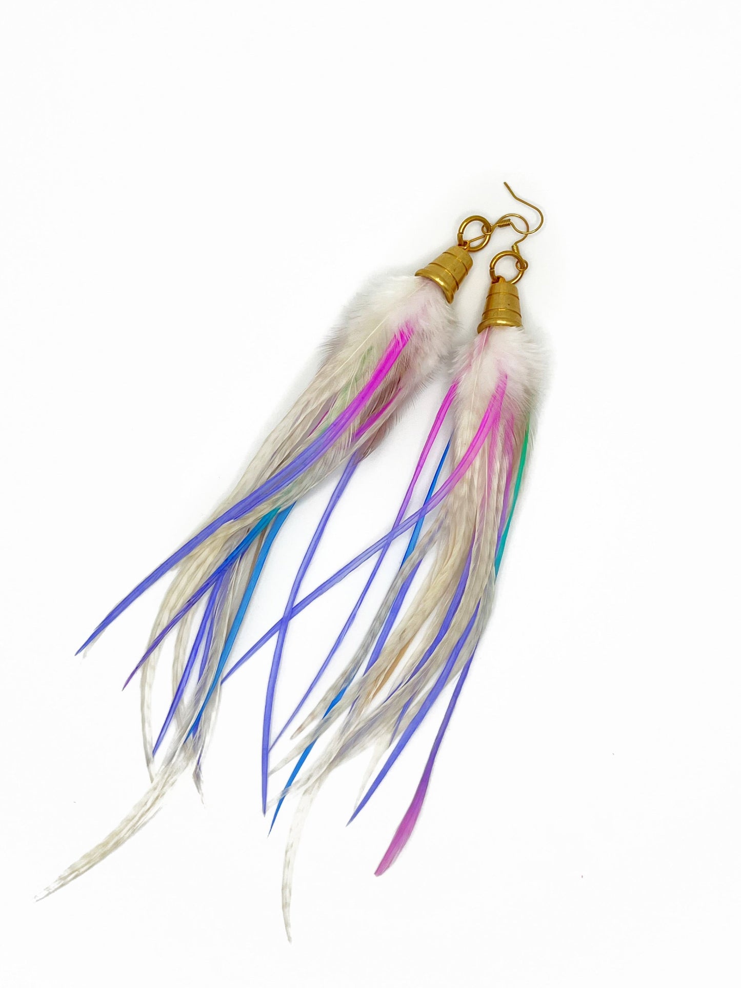 Long white feather earrings with pastel purple and pink accents. All feathers hang from beneath a gold cap pendant. 