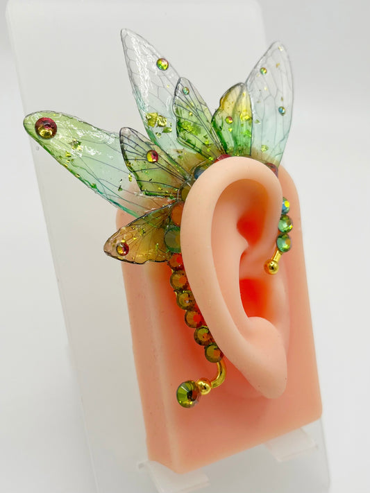 Green fairy wing ear cuff with rhinestone accents, modeled on an ear.