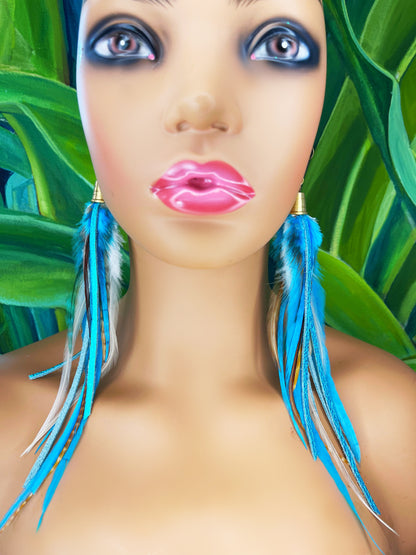 A mannequin wearing long turquoise blue feather earrings with strips of metallic leather, hanging from a gold colored cap pendant.