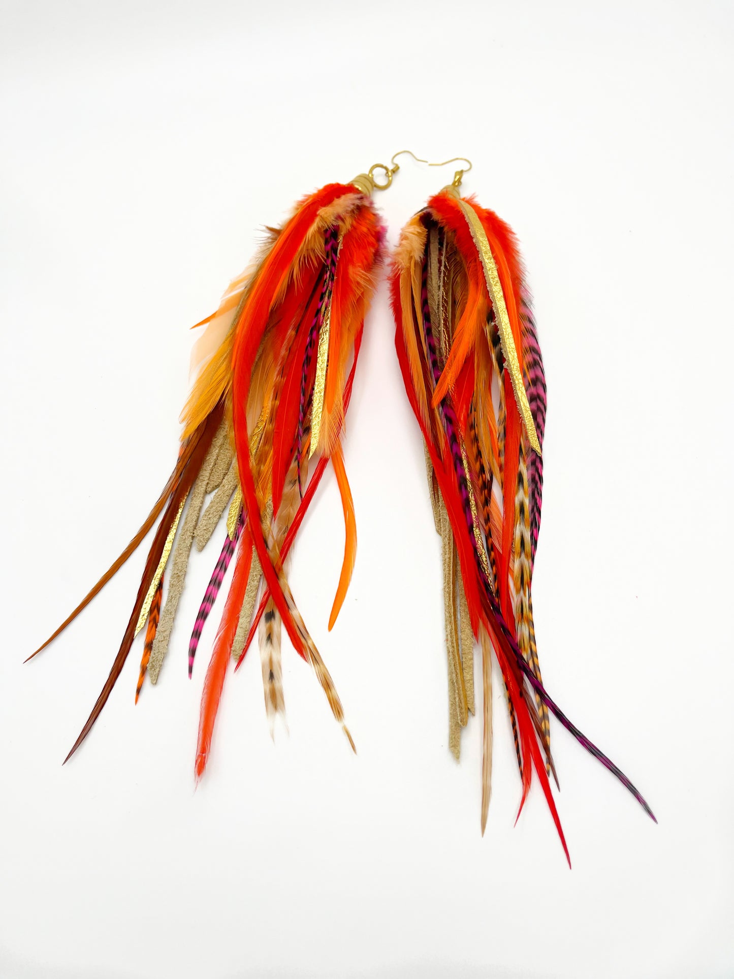 Long bohemian feather earrings with bright orange feathers, metallic gold leather and gold colored pendants.