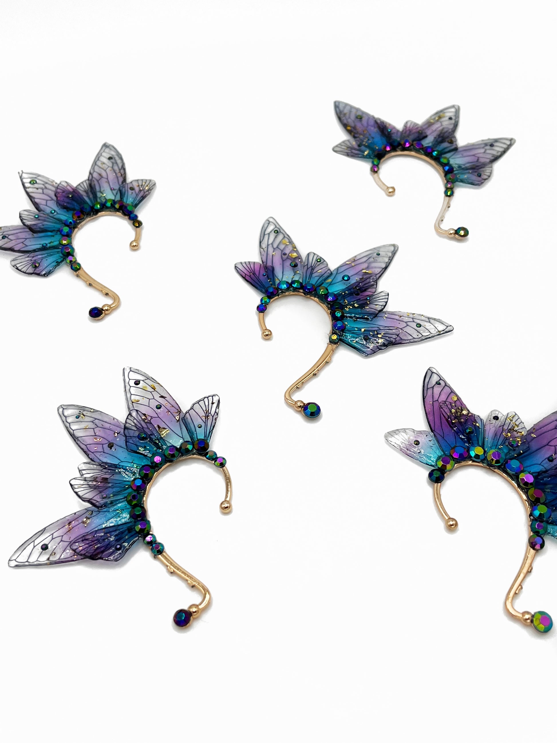 Purple and blue fairy wing ear cuffs with blue rhinestone accents.