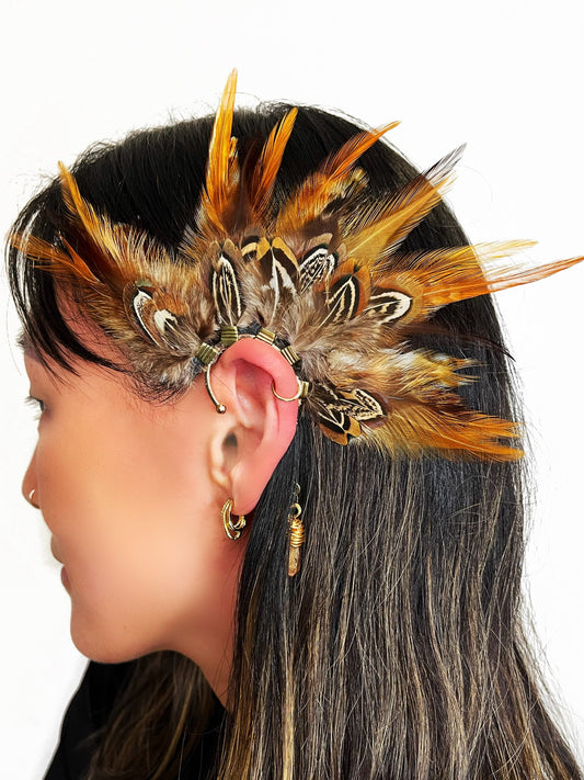 Rooster and pheasant feather ear cuff in brown and beige colors, modeled on a woman.