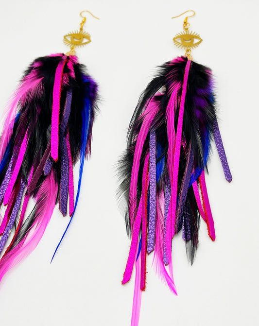 Long bohemian feather and leather earrings in black, pink and purple tones, hanging from a gold eye pendant.