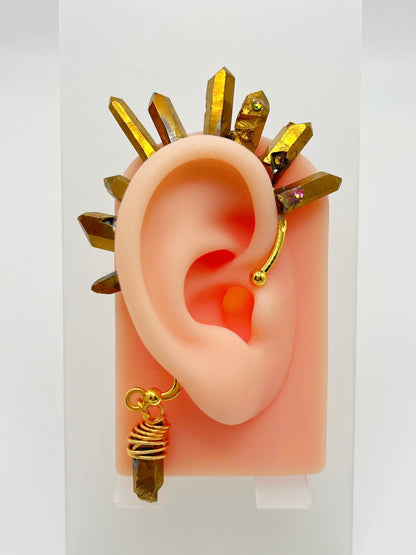 Gold pyrite quartz crystal ear cuff with rhinestones, modeled on an ear. A wire wrapped stone hangs from the bottom of the cuff behind the ear.