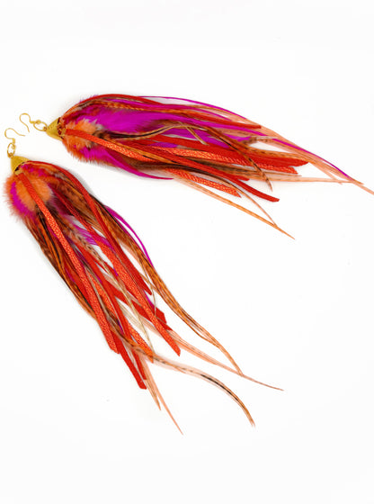 Two colorful fishing lures with red, pink, and orange hues on a white background.