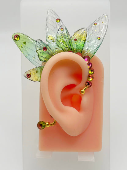 Green fairy wing ear cuff with rhinestone accents, modeled on an ear.