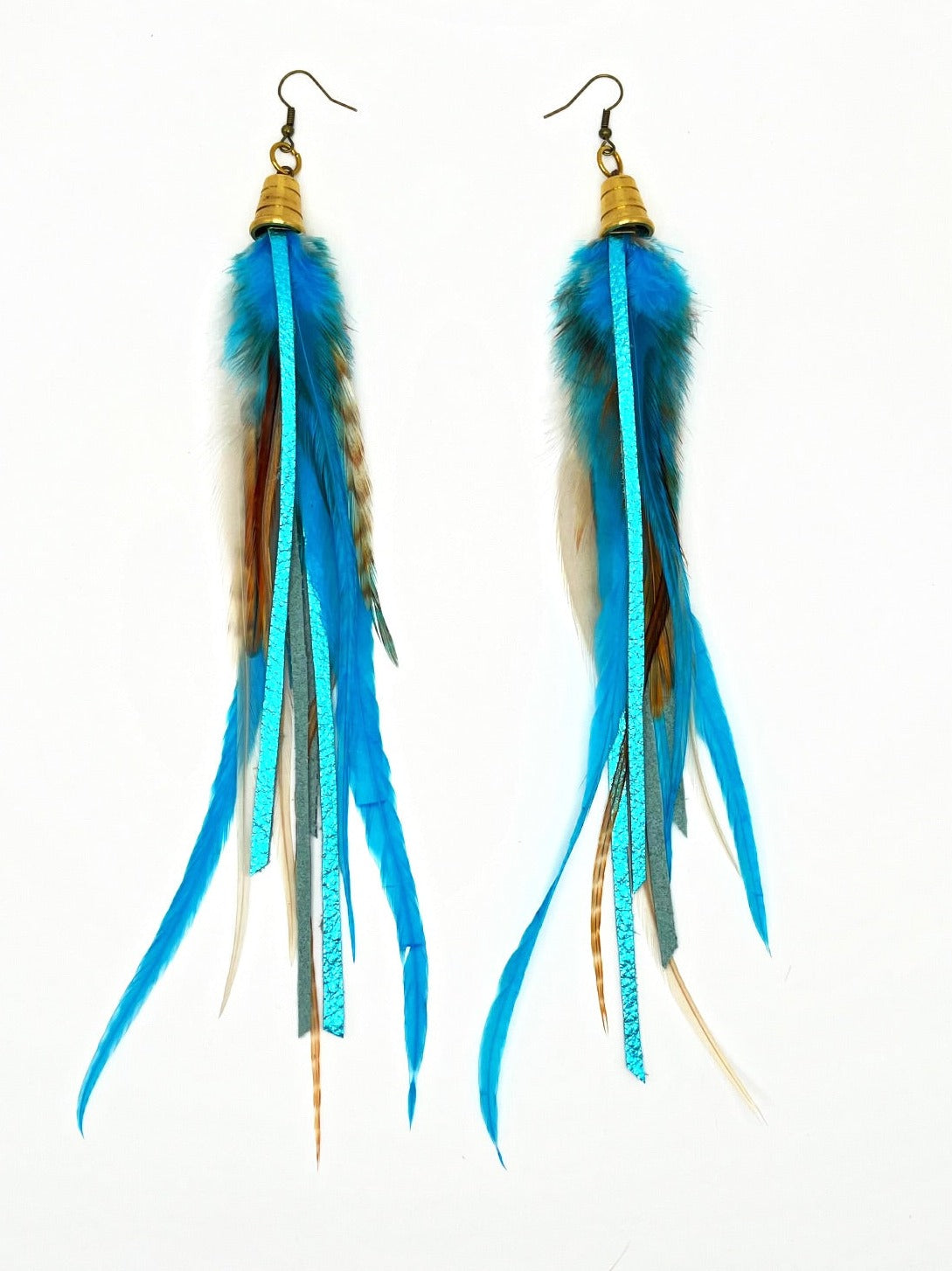 Long turquoise blue feather earrings with strips of metallic leather, hanging from a gold colored cap pendant. 