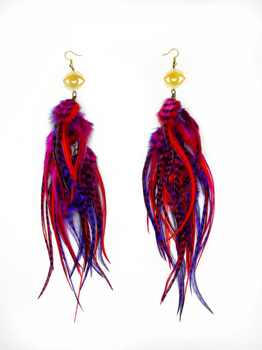 Long fluffy feather earrings in red and purple tones. All feathers hang elegantly from an evil eye pendant. 