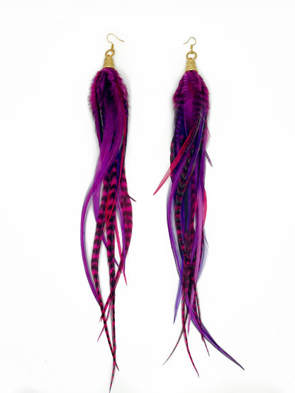 Long purple and pink feather earrings. All feathers hang elegantly from underneath an gold cap pendant. 