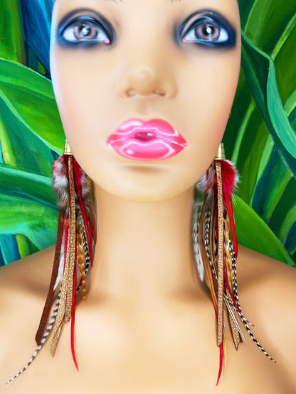 A mannequin wearing long feather earrings in brown and deep red, with metallic bronze leather strips, hanging from a gold colored cap pendant.