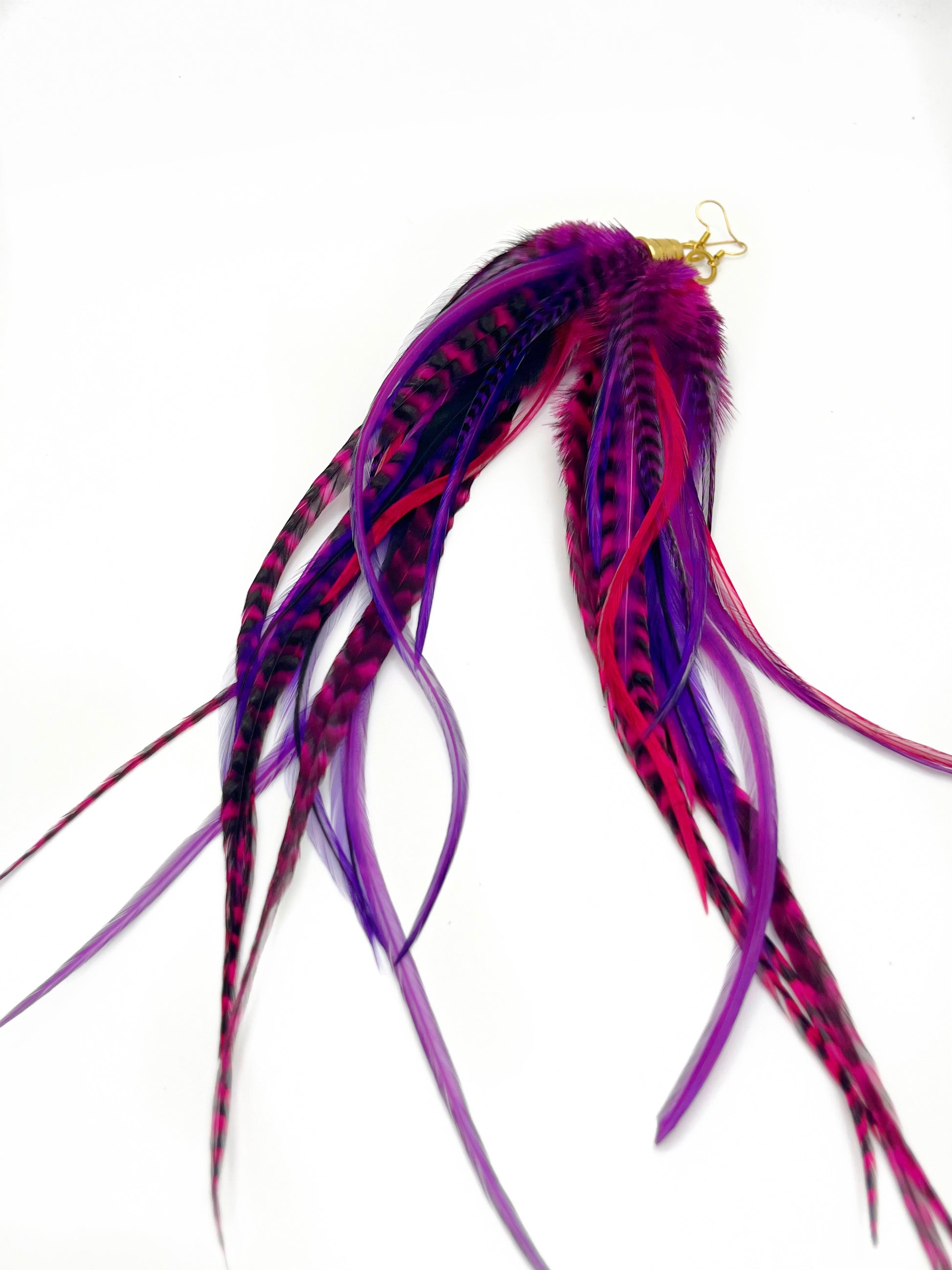 Long purple and pink feather earrings. All feathers hang elegantly from underneath an gold cap pendant. 