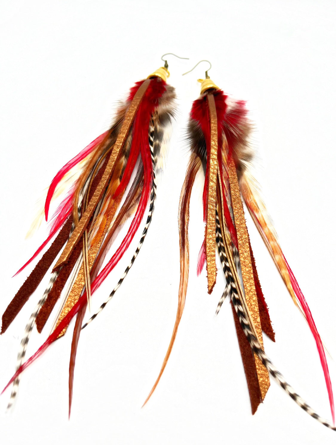 Long feather earrings in brown and deep red, with metallic bronze leather strips, hanging from a gold colored cap pendant.