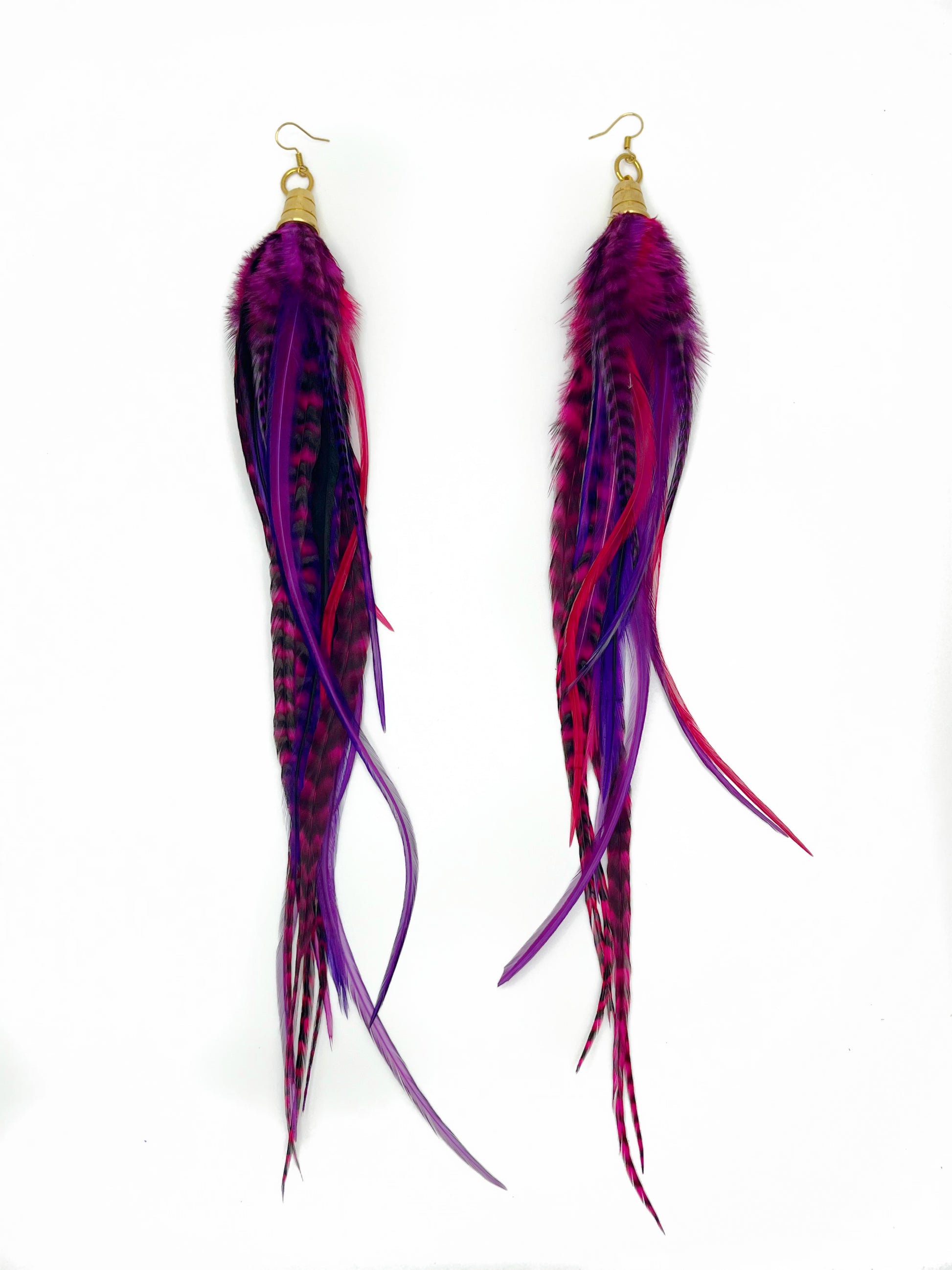 Long purple and pink feather earrings. All feathers hang elegantly from underneath an gold cap pendant. 