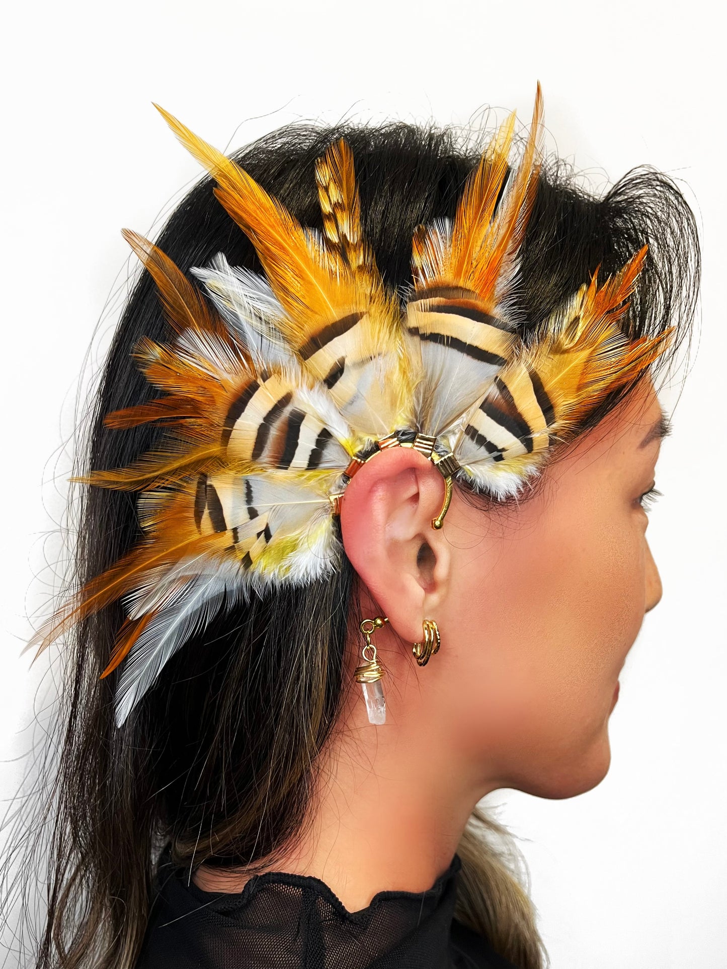 Rooster and chukar partridge feather ear cuff in white, cream, yellow and beige tones, modeled on a woman. 