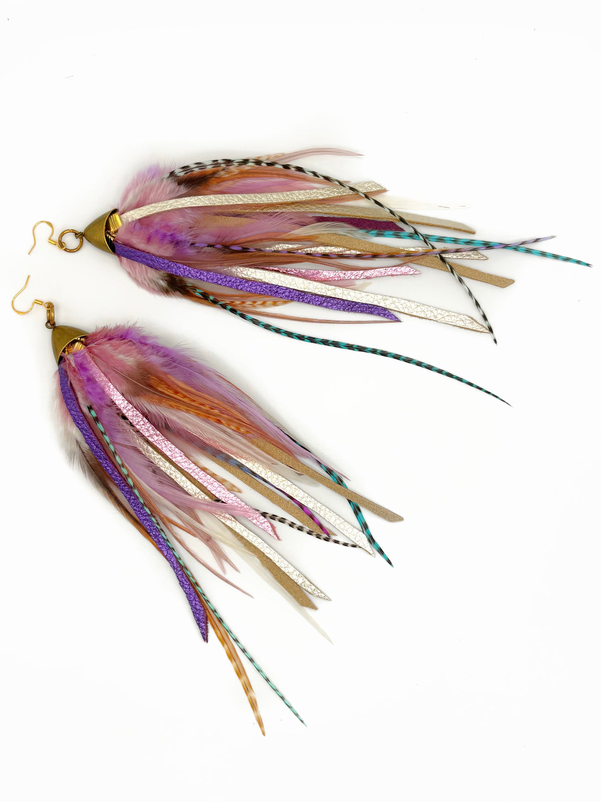 A pair of handmade feather earrings with gold-tone hooks and bodies, featuring a mix of pink, purple, white, and teal feathers on a plain white background.