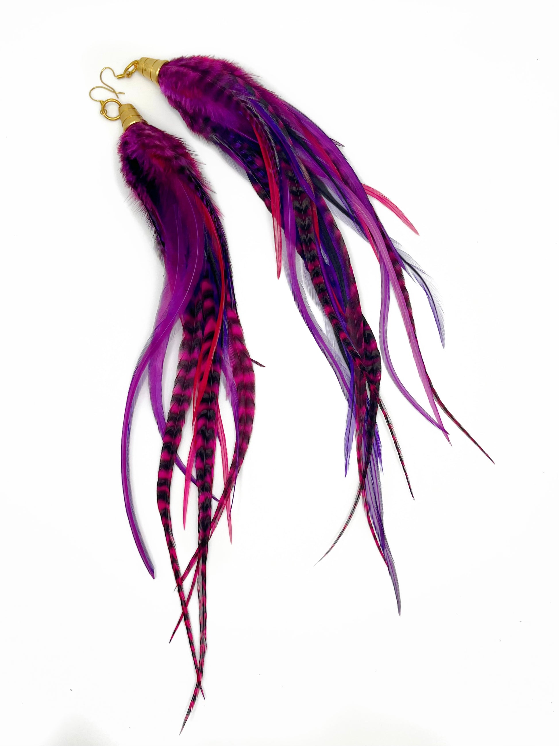 Long purple and pink feather earrings. All feathers hang elegantly from underneath an gold cap pendant. 