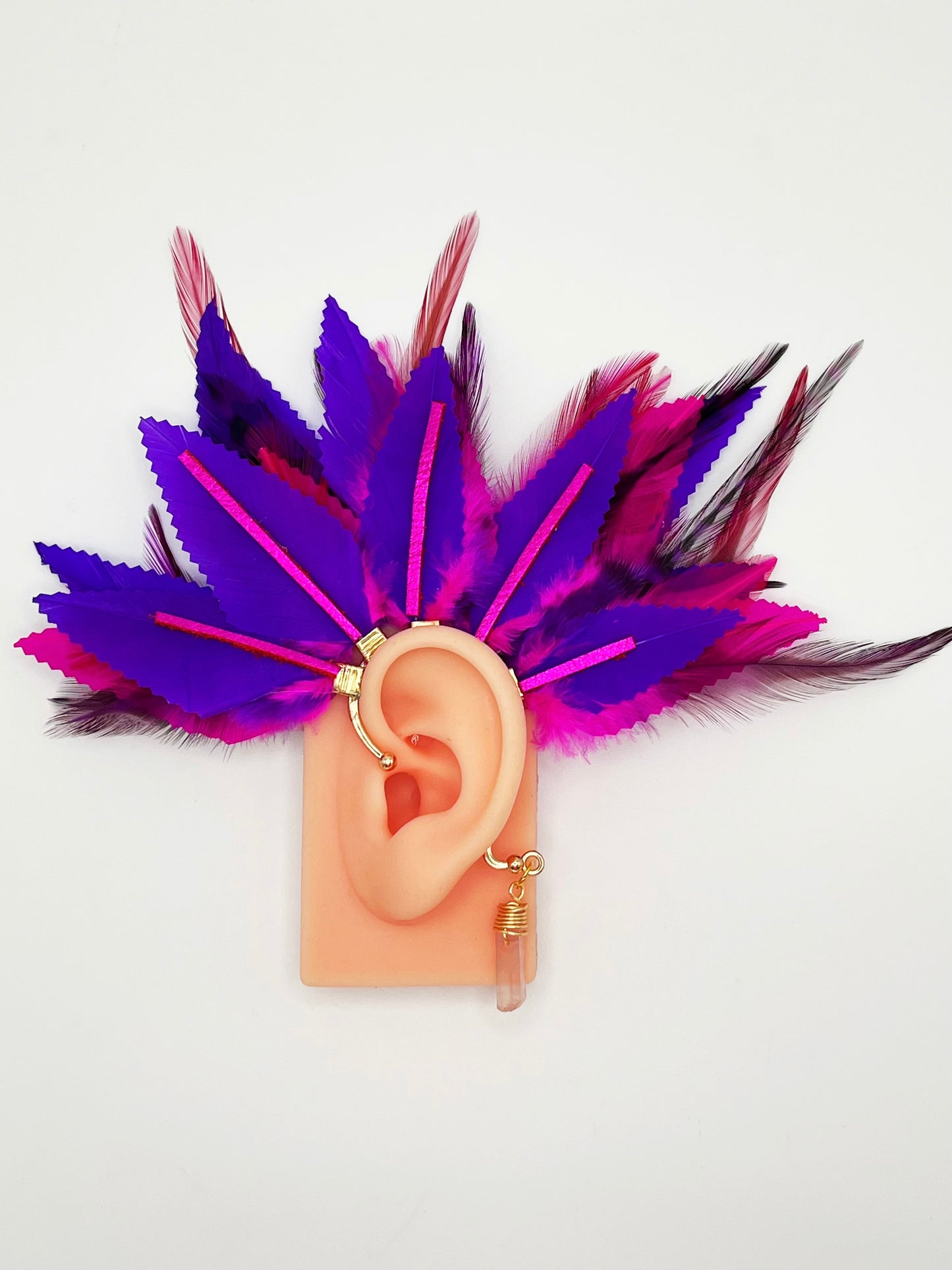 Structured purple and pink feather ear cuff with pink leather accents and a wire wrapped quartz, modeled on an ear.